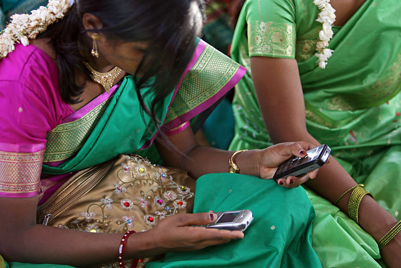 Woman in India wearing a sari, looking at her mobile phone 