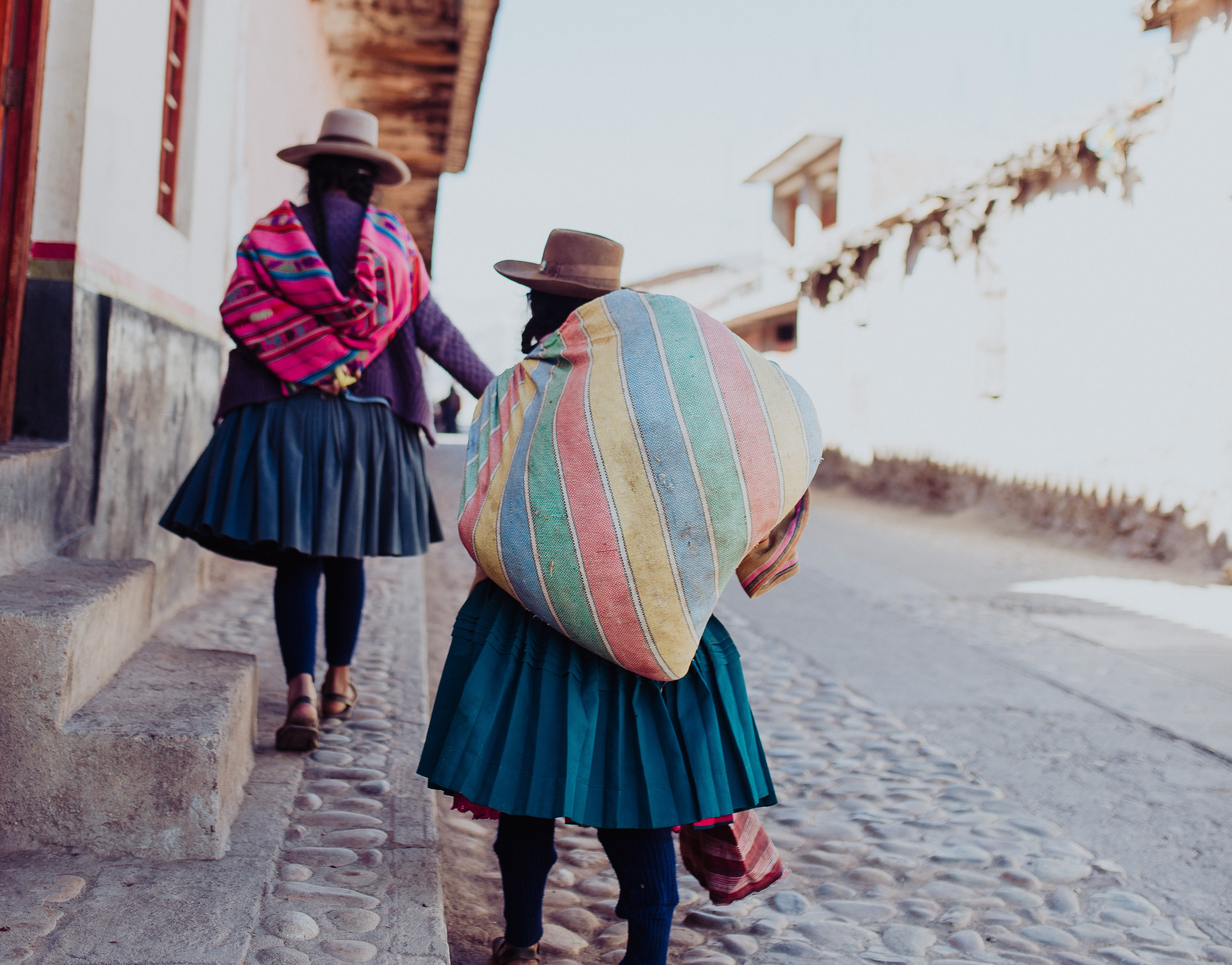 Two Peruvian women walking down a street 